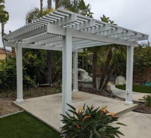 a free-standing pergola covering a patio in a yard