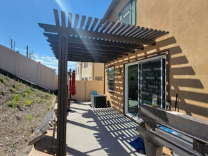 a pergola covering a patio behind a home